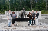 stephen colley and others surround the statue Artist and Educator Stephen Colley Completes Life-Sized Veterans Sculpture